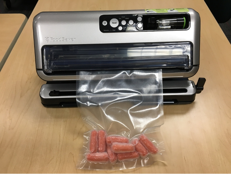 Photo of a vacuum sealer, with carrots.