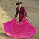 A matador with a bright pink cape.