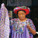 A woman holding up bright purple cloth.