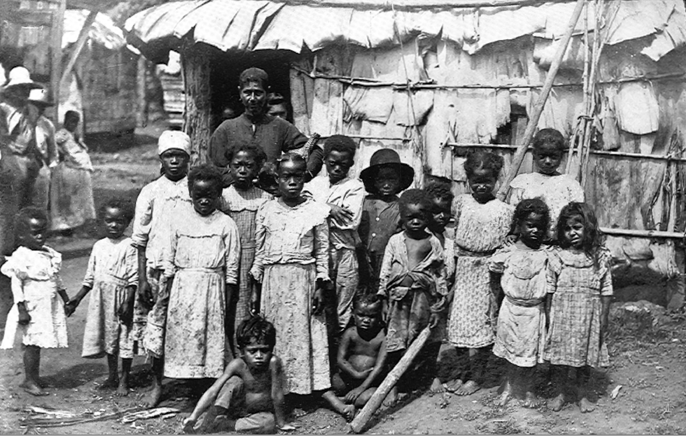 A black-and-white photo of a group of African-descended Puerto Rican children in front of a shelter.