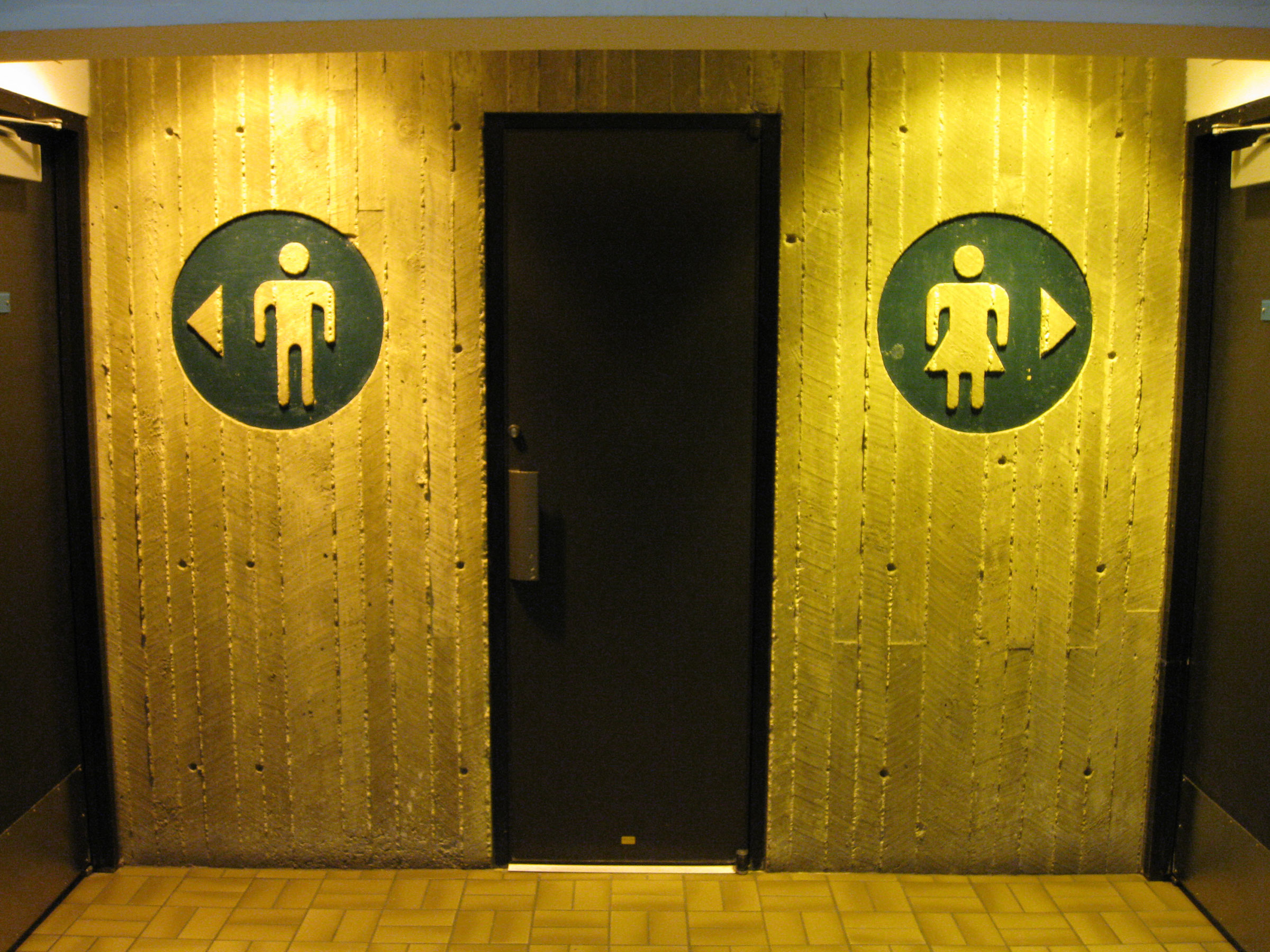 Bathroom signs for male and female bathrooms on a wall.