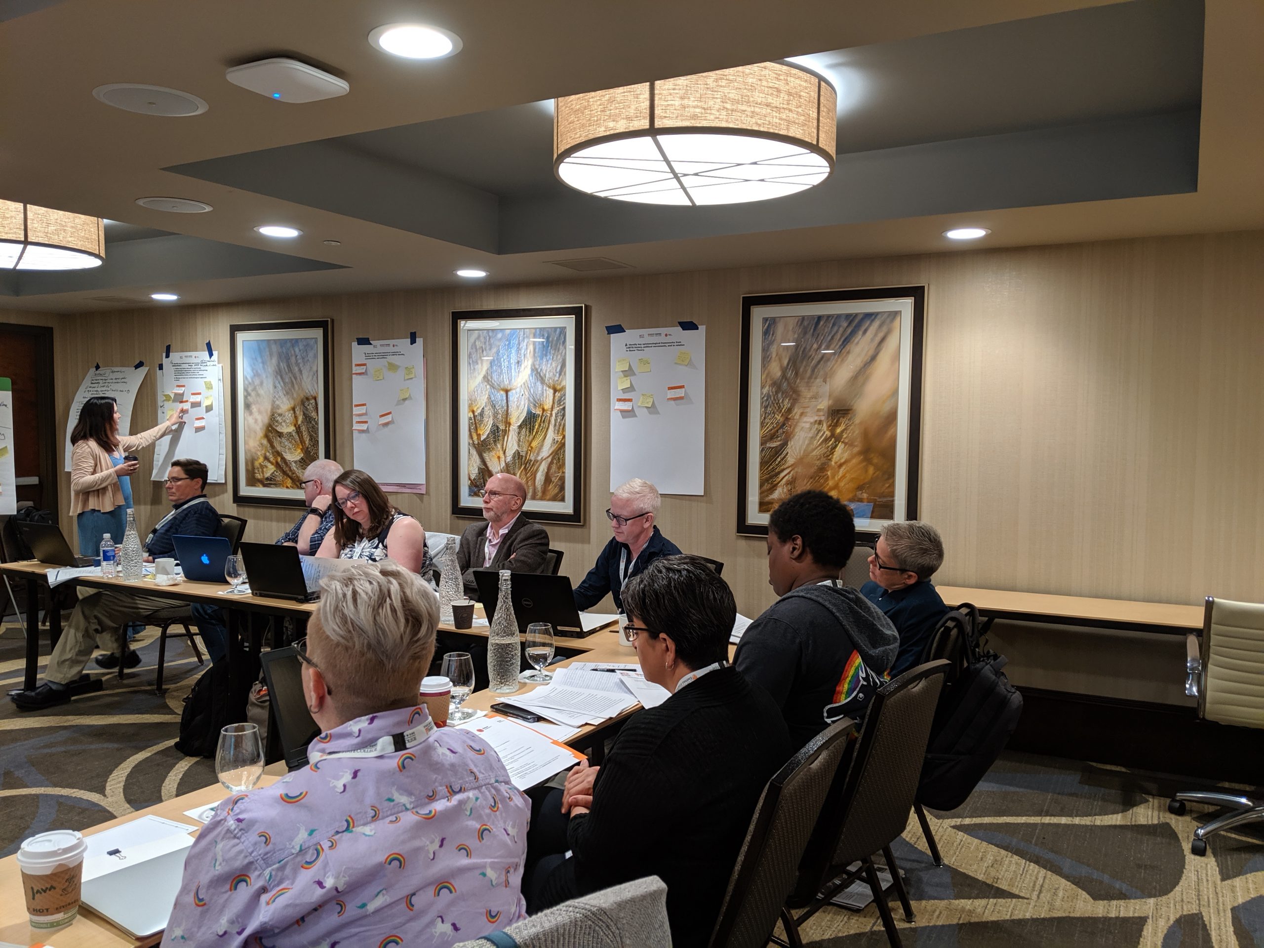 Authors sit around a table discussing the learning objectives of the text.