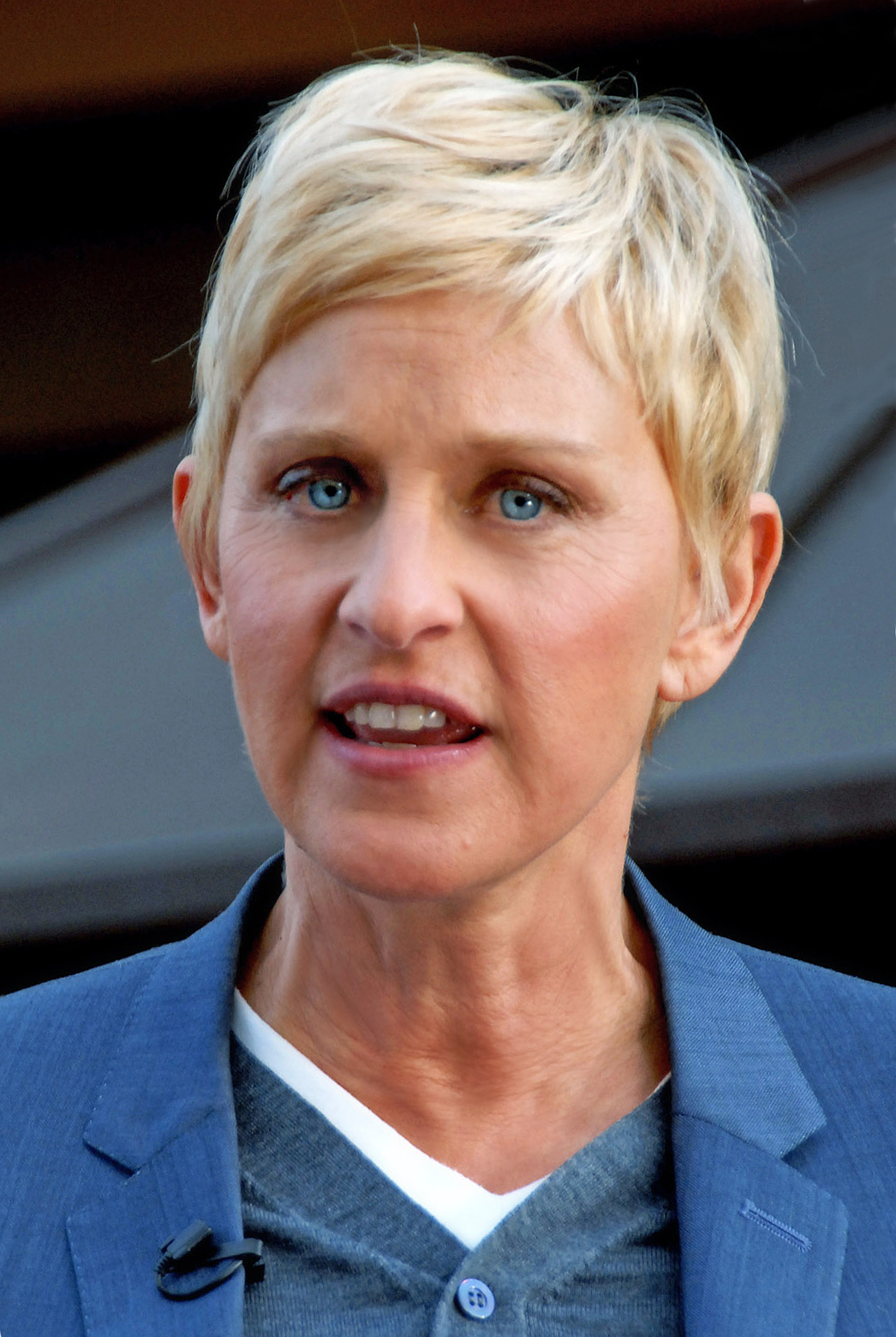 A woman with blonde hair and blue eyes looks at the camera.