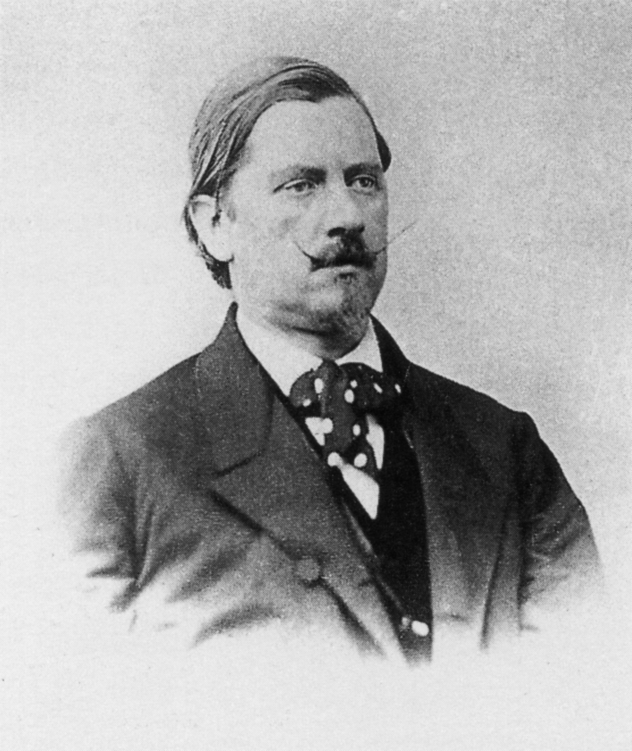 Old photography of a man with a pointy mustache.