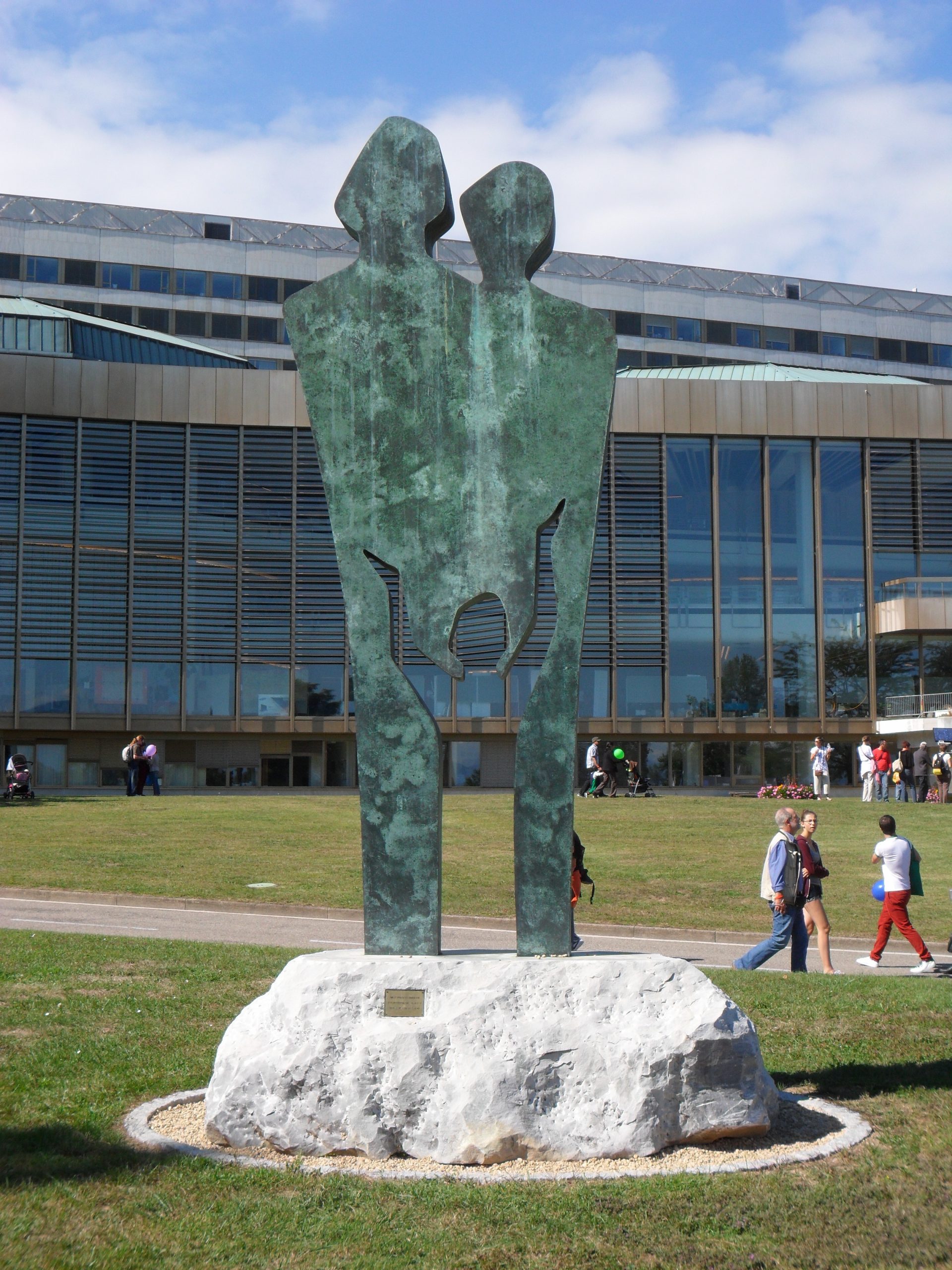 A bronze statue of two silhouettes with a smaller silhouette.