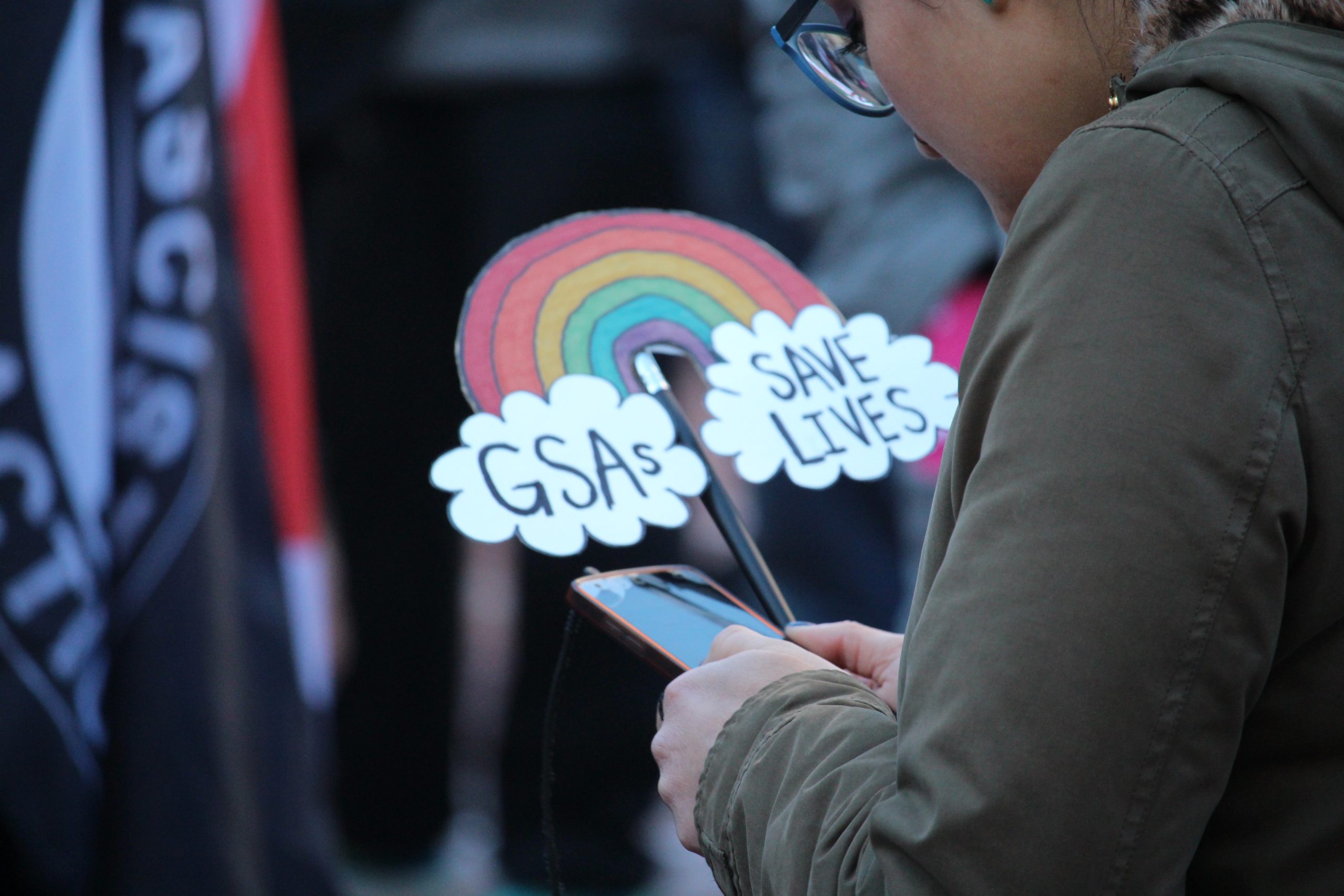 A rainbow sign says "GSAs SAVE LIVES."
