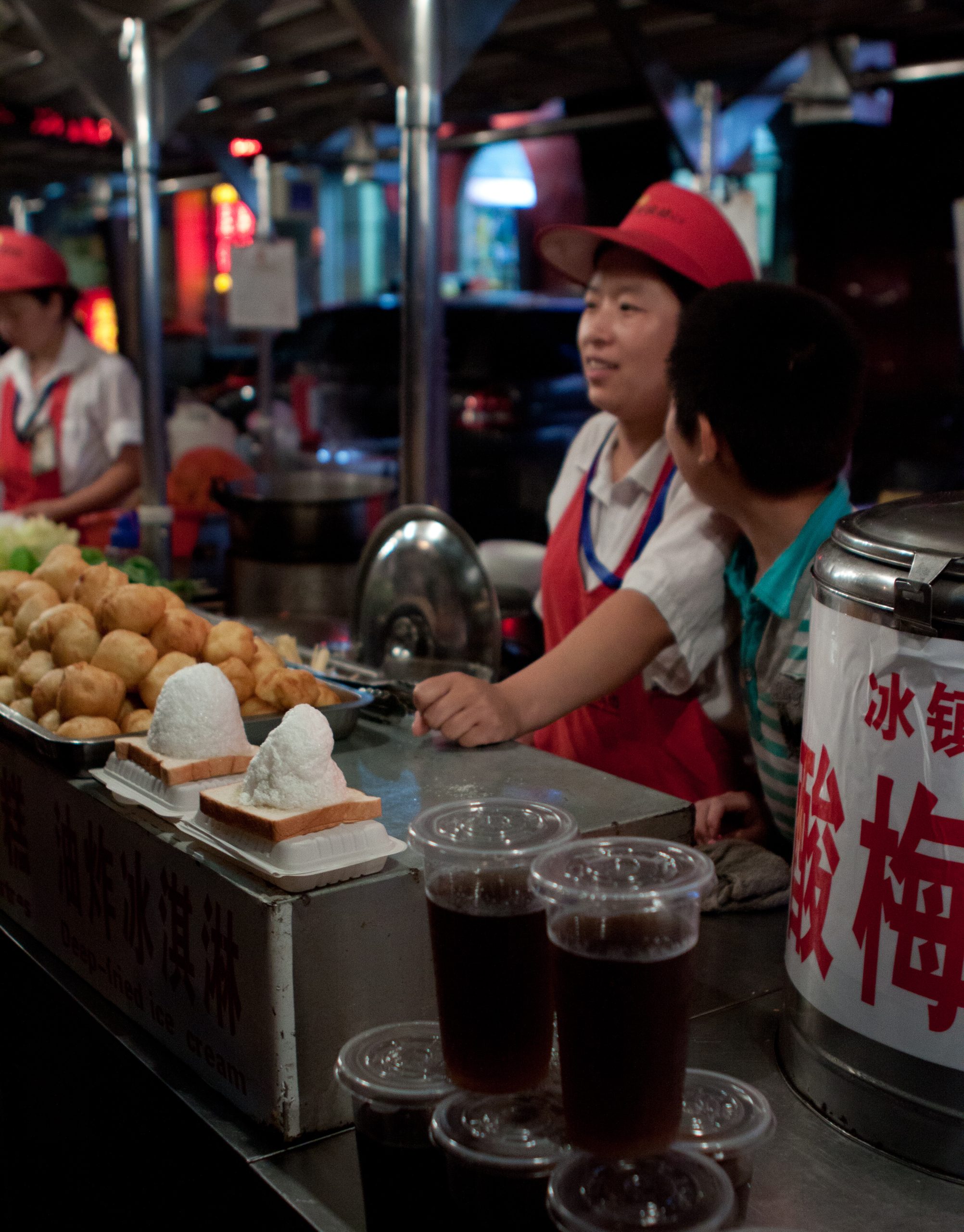 A vendor behind a counter offers street food for sale